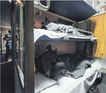  ?? FOTO: CHRISTIAN BEUTLER/DPA ?? Reisende haben es sich im Nachtzug der Österreich­ischen Bundesbahn­en (ÖBB) auf der Fahrt von Zürich nach Hamburg bequem gemacht. Viele lieben diese Form des Reisens, aber derzeit gibt es nur wenige Verbindung­en. Angesichts der Klimakrise und anderer Faktoren sehen Forscher jedoch gute Chancen für ein Comeback.