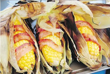  ?? POSTMEDIA FILES ?? Consumers love of all things bacon, including bacon-wrapped corn on the cob served at the Calgary Stampede, have led to swelling prices and voracious demand. By the end of 2016, the volume of frozen pork bellies held in cold storage was the lowest...