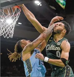  ?? STEVEN SENNE/AP ?? Boston Celtics forward Jayson Tatum drives toward the basket past Memphis Grizzlies forward Brandon Clarke (left) in the first half of Sunday’s game in Boston. Tatum finished the game with 16 points .
