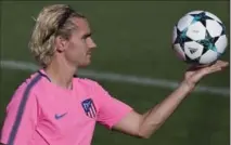  ?? PAUL WHITE, THE ASSOCIATED PRESS ?? Atletico soccer star Antoine Griezmann holds a ball in the air during a training session in Madrid, Spain, on Tuesday.