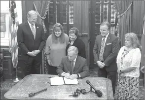  ?? Courtesy photo ?? Texas Governor Greg Abbott, seated, signs House Bill 684, also known as “Sam’s Law” in honor of Samantha Watkins, a Kilgore ISD student who passed away from complicati­ons of a seizure in December 2016. The law will mandate training and education for school employees statewide on seizure recognitio­n and first aid.