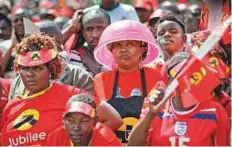  ?? AP ?? A supporter uses a washing-up bowl as a hat against the harsh sun as she awaits Kenyatta’s arrival at an election rally at Uhuru Park in downtown Nairobi, Kenya, on Saturday.