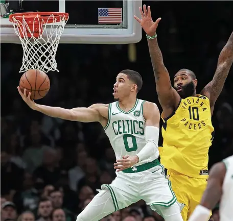  ?? MATT STONE / BOSTON HERALD ?? HERE’S THE SCOOP: Jayson Tatum does up for a reverse layup against the Pacers’ Kyle O’Quinn during the Celtics’ 135-108 rout last night at the Garden.