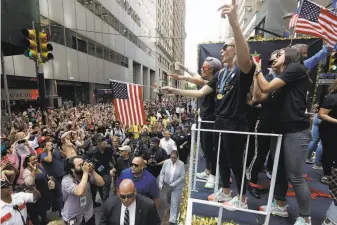  ?? Richard Drew / Associated Press ?? The U.S. women’s soccer team, including Megan Rapinoe (far left on float), enjoys a parade in the Canyon of Heroes. New York Mayor Bill de Blasio said the team “brought us together.”