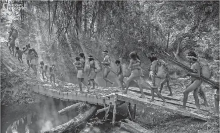  ?? CHARLIE HAMILTON JAMES/NATIONAL GEOGRAPHIC ?? Charlie Hamilton James photograph­ed the endangered tribes of the Amazon for the October 2018 issue of National Geographic magazine. Here, five families from Posto An outpost, created by the Brazilian government’s Indigenous Affairs Agency, set out on an overnight excursion into the forest.