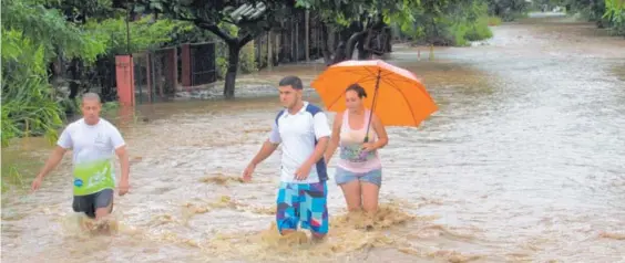  ?? ÁLVARO DUARTE ?? El río Diría puso en apuros a los vecinos de Santa Cruz quienes no tuvieron más remedio que quedar empapados.