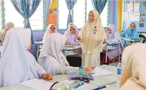  ??  ?? Pelajar yang terpilih menjadi guru muda berkongsi ilmu dengan rakan-rakan ketika sesi pembelajar­an di SMK Maahad Hamidiah.