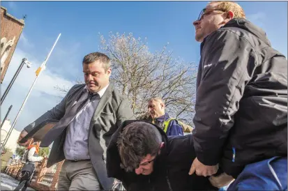  ?? Photo by Michael Mac Sweeney ?? Denis O’Brien (head down, centre) is brought into Cork Court on Monday.