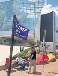  ?? [AP PHOTO/ TOM MCCARTHY] ?? James Massery, left, of Preston, and Daniel Hedman, of Tulsa, supporters of President Donald Trump, camp outside the BOK Center in Tulsa.