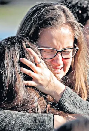  ??  ?? Parents comfort each other after the recent shooting at Marjory Stoneman Douglas High School in Florida