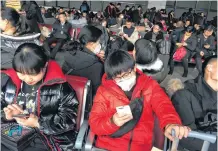  ?? REUTERS ?? Passengers wearing masks are seen at the waiting area for a train to Wuhan at the Beijing West Railway Station, ahead of the Chinese Lunar New Year, in Beijing, China, on Monday.