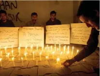  ?? /AP PHOTO/ SHAKIL ADIL ?? GRIEF. Pakistani students light candles to condemn the attack on a shrine in interior Sind province in Karachi, Pakistan.