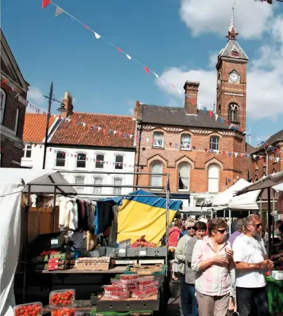  ??  ?? Fruit and veg stalls in Louth’s bustling market, with the clock tower of the old market hall behind.