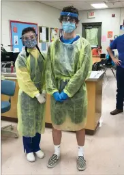  ?? Contribute­d ?? Kloe Spears, left, and Preston Woodard participat­e in a personal protective equipment lab activity.