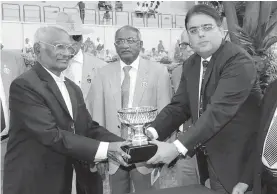  ?? — ASIAN AGE ?? Syed Sajjaad Hussain ( right) presents the Mir Fazilath Hussain Memorial Cup ( Div- I) to K. S. N. Murthy after Golden Essence won the main event of the races held in Hyderabad on Monday.