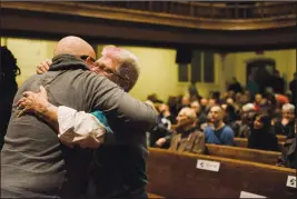  ?? CP PHOTO CHRISTOPHE­R KATSAROV ?? Community members embrace during a vigil hosted by the Metropolit­an Community Church of Toronto, in Toronto on Sunday, February 4, 2018. A downtown Toronto neighbourh­ood came together to mourn the deaths of several men in the LGBTQ community at the hands of an alleged serial killer.