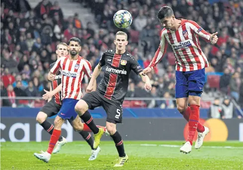  ??  ?? Atletico Madrid’s Alvaro Morata, right, heads the ball to score against Leverkusen in the Champions League.