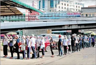  ?? AFP ?? People queue to be tested for the Covid-19 coronaviru­s at a seafood market in Samut Sakhon, after some new cases of local infections were detected and linked to a vendor at the market.