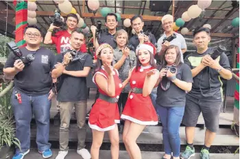  ??  ?? Demong (back row, centre) and fellow photograph­ers gather for a photo-call with Marzella and Eka (front, third and fourth right, respective­ly). — Photo by Chimon Upon