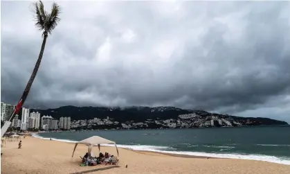  ?? Photograph: David Guzman/EPA ?? Clouds hover over a beach in the resort of Acapulco in Mexico. Mexico expects tropical storm Hilary, the eighth named cyclone of the season, to intensify into a hurricane.