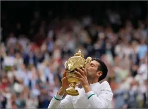  ??  ?? The Associated Press
Serbia’s Novak Djokovic kisses the trophy after defeating Italy’s Matteo Berrettini in the men’s final at Wimbledon in London, Sunday.