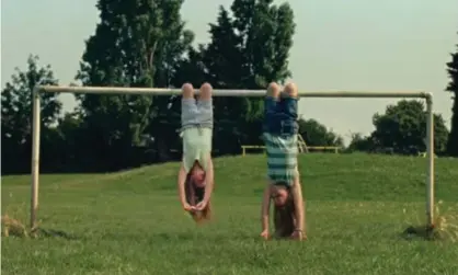  ?? Photograph: Advertisin­g Standards Agency/PA ?? The Advertisin­g Standards Agency has banned over choking fears a Dairylea TV advert showing two girls hanging upside down from a football goal.