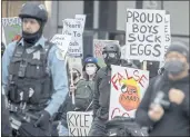  ?? PAT NABONG — CHICAGO SUN-TIMES VIA AP ?? People display signs as they march to Federal Plaza on Saturday in Chicago to protest the acquittal Friday of Kyle Rittenhous­e, 18, in Kenosha, Wis.