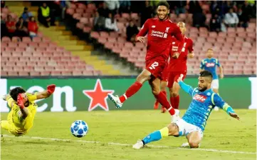  ?? — Reuters photo ?? Napoli’s Lorenzo Insigne (right) scores a goal against Liverpool during the UEFA Champions League group C match at the San Paolo stadium in Naples.