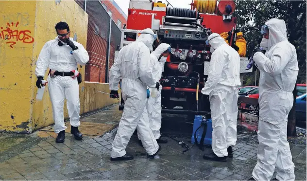  ?? Associated Press ?? ↑
Members of the Emergency Army Unit prepare to disinfect at a nursing home in Madrid, Spain.