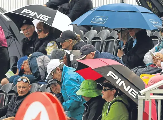  ??  ?? Golf fans rush for the umbrellas and waterproof­s yet again at the Women’s British Open in ‘mid-summer’.