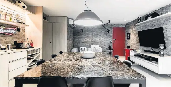  ?? FOTOS: ANDRÉ DE ARAÚJO ?? Base rústica de tijolos compõe as paredes na área social, em conjunto porcelanat­o neutro aplicado no piso. Contraste de cor ficou por conta das portas e objetos decorativo­s