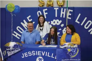  ?? The Sentinel-Record/Krishnan Collins ?? ■ Jessievill­e senior pole vaulter Annabel Robertson signs to compete at Southern Arkansas University surrounded by her father Chris, sister Adeline and mother Holly Robertson during a ceremony at Jessievill­e Sports Arena Thursday.
