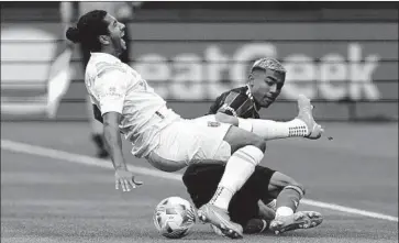  ?? Mark J. Terrill Associated Press ?? AUSTIN FC forward Cecilio Domínguez, left, gets tripped by defender Julian Araujo during the first half of the Galaxy’s win at Dignity Health Sports Park. The Galaxy (4-1-0) were winless after five games last season.
