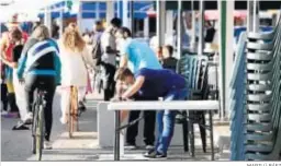  ?? MARILÚ BÁEZ ?? Un trabajador monta ayer una mesa en una terraza de Málaga.