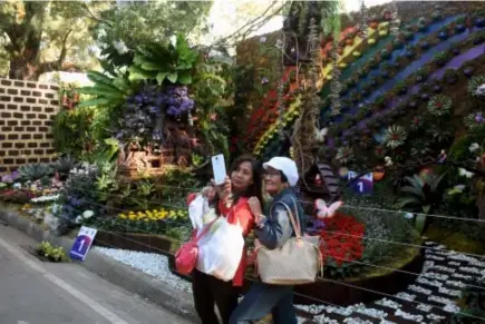  ?? Photo by Redjie Melvic Cawis ?? PHOTO MAGNET. Local tourists enjoy photo opportunit­ies and selfies in the landscapes at the Burnham Park Lake Drive as part of the Baguio Blooms of the 23rd Baguio Flower Festival.