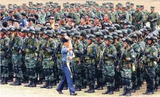  ??  ?? OFF FOR ELECTION DUTY – At the send-off ceremony in Camp Aquinaldo Tuesday, a priest blesses the contingent of police officers and soldiers who will be deployed for election duty. (Mark Balmores)