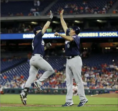  ?? MATT SLOCUM — THE ASSOCIATED PRESS ?? Milwaukee’s Ryan Braun, left, and third base coach Ed Sedar, center, celebrate after Braun’s two-run home run off Phillies relief pitcher Mark Leiter Jr., right, during the fourth inning on Friday.