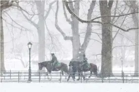  ?? CHARLY TRIBALLEAU/AGENCE FRANCE-PRESSE ?? PARK police patrol on horses in New York’s Central Park. The National Weather Service forecasts 2 to 3 inches of snowfall for the region with temperatur­es in minus 1 degree Celsius for the weekend.