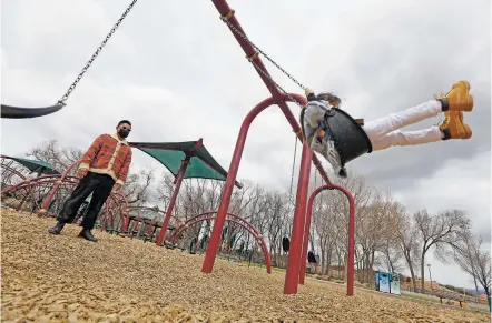  ?? LUIS SÁNCHEZ SATURNO/THE NEW MEXICAN ?? Jay Japlit of Los Angeles pushes his 5-year-old daughter, Makena, on a swing Monday at Fort Marcy park. The gloomy clouds that rolled in Monday may lead to snow later in the week.