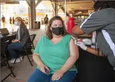  ?? Emily Matthews/Post-Gazette ?? Kristy Sickles, of Plum, gets her first COVID-19 vaccine from Giant Eagle pharmacist Chisom Amaeze, of Downtown, before the Steelers preseason game against the Detroit Lions on Aug. 21 at Heinz Field on the North Shore.