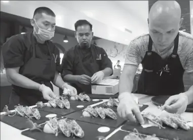 ?? BEA AHBECK/NEWS-SENTINEL ?? M Sushi Bistro chefs Anthony Term, Judeasar Jojo and executive chef and owner Minh Nguyen prepare a taco trio dish for a booked birthday party at the newly opened M Sushi Bistro on Friday in Downtown Lodi.