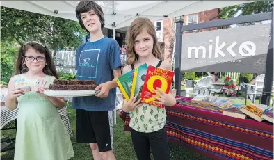  ?? PETER McCABE ?? Erin Plessis, left, Felix Antoine Prieur and Penelope-Lili Prieur sell various products in front of Hudson’s Mikko Espresso & Boutique as part of the fifth annual Young Entreprene­urs Day on Saturday. The day allowed children to sell crafts or other...