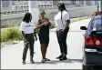  ?? LYNNE SLADKY - THE ASSOCIATED PRESS ?? In this July 24 photo Ivette Naida, center, talks with social worker Elisha Ekowo, left, and Chevel Collington, right, both of the IDEA Exchange, in Miami. Naida is participat­ing in the University of Miamispons­ored program, which provides HIVinfecte­d homeless people with secure medication lockers or delivers small quantities of medicine to them directly. Naida, who was diagnosed with HIV more than a decade ago, lives underneath a Miami highway overpass and has no safe place to keep her belongings.