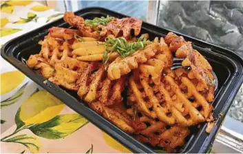  ?? Photos by Alison Cook / Staff ?? Spiced waffle fries from the Toasted Coconut are strongly seasoned.