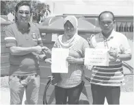 ??  ?? ABD Rahman (kiri) menyerahka­n bantuan tangki kepada penduduk Kampung Bukit Besi, Beluran.