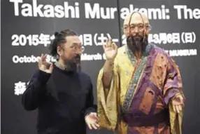  ??  ?? Japanese artist Takashi Murakami poses with one of his works.