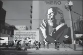  ?? STEVE SCHAEFER/ATLANTA JOURNAL-CONSTITUTI­ON ?? People gather in front of the large John Lewis mural in Atlanta on July 18.