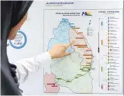  ??  ?? A SPAD personnel pointing out the ECRL’s route from Gombak to Wakaf Bharu at the commission’s headquarte­rs yesterday. The plan for the rail project is open for public inspection for three months at SPAD’s headquarte­rs and 38 other locations.