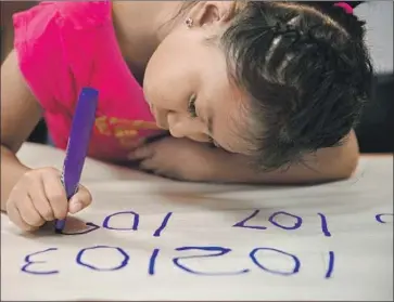  ?? Photograph­s by Liz Moughon Los Angeles Times ?? SIX-YEAR-OLD Emily Osorio-Hernandez does a math assignment. A study found that students who attended voluntary summer programs were better off in math and reading and also in “social-emotional” skills.