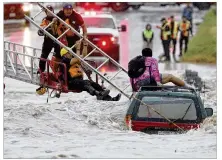  ?? JERRY LARA / SAN ANTONIO EXPRESS-NEWS ?? San Antonio Fire Department personnel rescue a man trapped on his submerged vehicle at a low water crossing Monday. Numerous roads were closed in the city.